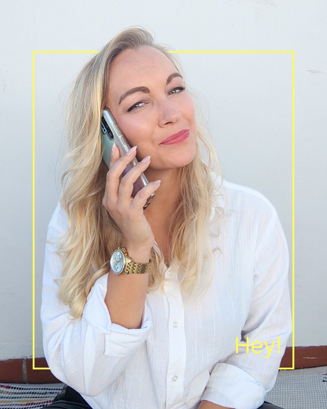 Jennifer Werner. Social Media Managerin und Virtuelle Assistentin – telefoniert entspannt mit dem Smartphone, trägt eine weiße Bluse und sitzt in einem modernen Setting mit gelbem Rahmen. Sie steht für authentisches Marketing und strategische Sichtbarkeit auf Social Media.